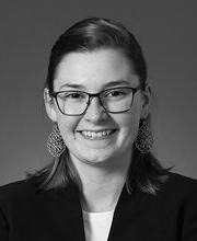 black and white headshot of Rebecca Fleming smiling and wearing glasses with her hair pulled back and large teardrop earrings