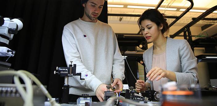 Dr. Elif Demirbas working with a student in BSU photonics lab